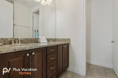 a bathroom with a sink and a large mirror at 331 Villa SpaPool- GamesTheater by Disney in Orlando