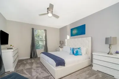 a white bedroom with a bed and a ceiling fan at 2741MA VILLA 5 BED/5 BA (SANITIZED) in Kissimmee