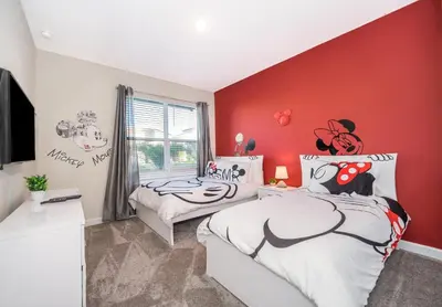 a bedroom with two beds and a red wall at 2741MA VILLA 5 BED/5 BA (SANITIZED) in Kissimmee