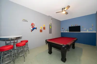 a room with a ping pong table and stools at 2741MA VILLA 5 BED/5 BA (SANITIZED) in Kissimmee