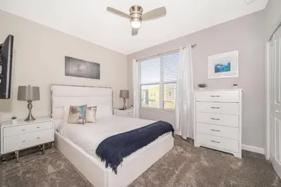 a white bedroom with a bed and a window at 2741MA VILLA 5 BED/5 BA (SANITIZED) in Kissimmee