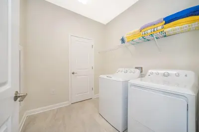 a laundry room with a washer and dryer at 2741MA VILLA 5 BED/5 BA (SANITIZED) in Kissimmee