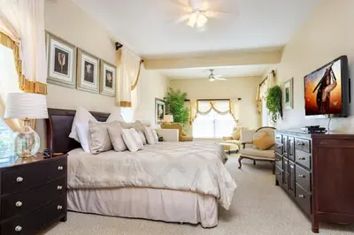 a bedroom with a large bed with a dresser and a couch at Mickeys Floridian - Glorious 5BR Private South Facing Pool Hot Tub Game RM GYM BBQ - 2 miles to Disney in Orlando