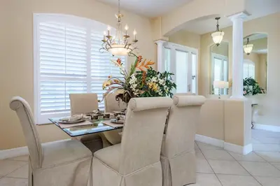 a dining room with a table and chairs and a chandelier at Mickeys Floridian - Glorious 5BR Private South Facing Pool Hot Tub Game RM GYM BBQ - 2 miles to Disney in Orlando