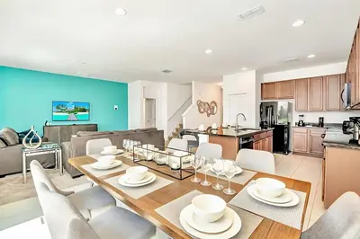 a kitchen and living room with a table and chairs at Family Resort - 6BR Mansion - Private Pool, Home Theater, BBQ and More in Kissimmee
