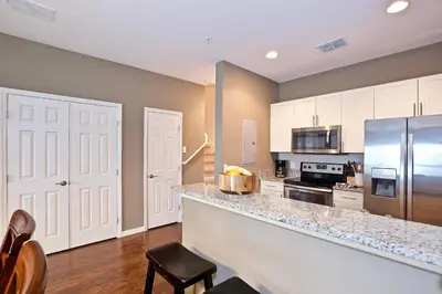 a kitchen with a counter and a stainless steel refrigerator at Great and practical townhouse in gated community, sleeps 6 10 min to Disney! in Orlando