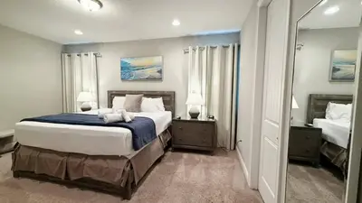 a bedroom with a large bed and a mirror at Encore Resort 6 Bedroom Home with Pool 2301 in Orlando