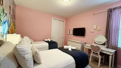 a bedroom with two beds and a desk and a television at Encore Resort 6 Bedroom Home with Pool 2301 in Orlando