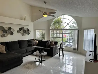 a living room with a couch and a ceiling fan at ELEGANT & LUXURIOUS FAMILY APARTMENT close to DISNEY WORLD in Kissimmee