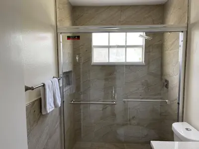 a bathroom with a shower with a toilet and a window at ELEGANT & LUXURIOUS FAMILY APARTMENT close to DISNEY WORLD in Kissimmee
