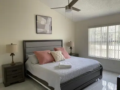 a bedroom with a bed with pink and white pillows at ELEGANT & LUXURIOUS FAMILY APARTMENT close to DISNEY WORLD in Kissimmee