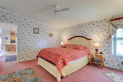 a bedroom with a bed with a red comforter at Steps to Pool Winter Garden House with Lanai! in Orlando