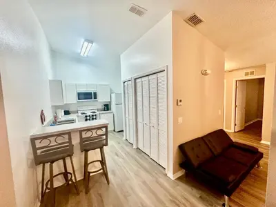 a kitchen with a table and a couch in a room at Grand Holiday 3BR Palms Condo near Disney Parks in Kissimmee