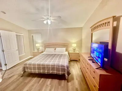 a bedroom with a bed and a flat screen tv at Grand Holiday 3BR Palms Condo near Disney Parks in Kissimmee