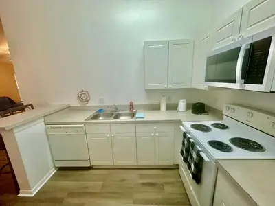 a white kitchen with a sink and a stove at Grand Holiday 3BR Palms Condo near Disney Parks in Kissimmee