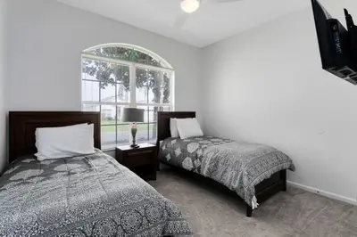 a bedroom with two beds and a window at Immaculate 4 bedrooms 3 bathroom in Windsor Palms villa in Kissimmee