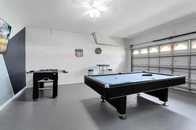a room with a pool table in a garage at Immaculate 4 bedrooms 3 bathroom in Windsor Palms villa in Kissimmee