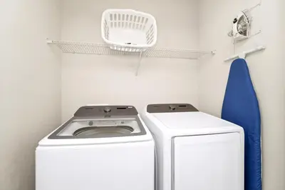 a washer and dryer in a laundry room at Gleaming Home With Private Pool, Theater Room And Water Park Access Near Disney At Encore Resorts Reunion - 209Sf in Kissimmee