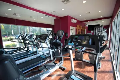 a gym with a row of treadmills and ellipticals at 5370 INCREDIBLE 8 MINS TO DISNEY LUCAYA VILLAGE RESORT in Kissimmee