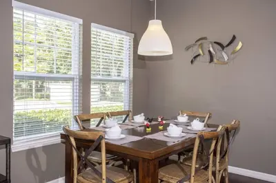 a dining room with a wooden table and chairs at 5370 INCREDIBLE 8 MINS TO DISNEY LUCAYA VILLAGE RESORT in Kissimmee