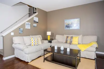 a living room with a white couch and a staircase at 5370 INCREDIBLE 8 MINS TO DISNEY LUCAYA VILLAGE RESORT in Kissimmee
