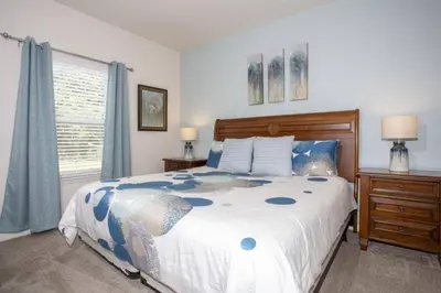 a bedroom with a large bed and a window at 5370 INCREDIBLE 8 MINS TO DISNEY LUCAYA VILLAGE RESORT in Kissimmee
