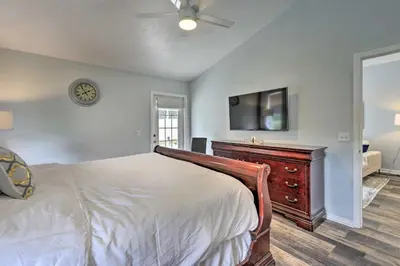 a bedroom with a bed with a dresser and a flat screen tv at Apopka Single-Story Home with Private Lanai and Pool! in Orlando