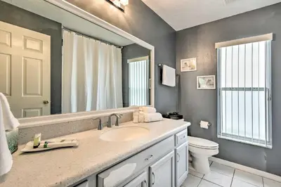 a bathroom with a sink and a toilet and a mirror at Apopka Single-Story Home with Private Lanai and Pool! in Orlando