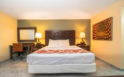 a bedroom with a bed and a desk with a computer at Sevilla Inn Kissimmee- Near Disney in Kissimmee