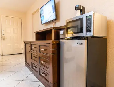 a kitchen with a microwave on top of a refrigerator at Sevilla Inn Kissimmee- Near Disney in Kissimmee