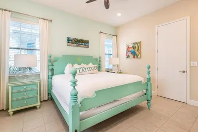 a bedroom with a green bed and a window at Sunny Yellow Cottage Near Disney With Margaritaville Resort Access & Island H20 Waterpark - 3075Kl in Orlando