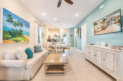 a living room with a couch and a table at Sunny Yellow Cottage Near Disney With Margaritaville Resort Access & Island H20 Waterpark - 3075Kl in Orlando