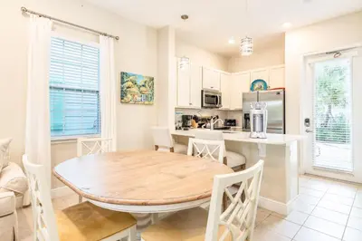 a kitchen and dining room with a wooden table and chairs at Sunny Yellow Cottage Near Disney With Margaritaville Resort Access & Island H20 Waterpark - 3075Kl in Orlando