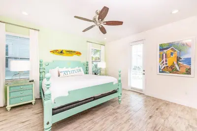 a bedroom with a blue bed and a ceiling fan at Love, Luck And Magic Cottage With Private Hot Tub Near Disney And Margaritaville Resort & Island H2O Access - 8013Ff in Orlando