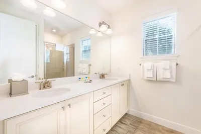 a white bathroom with a sink and a mirror at Love, Luck And Magic Cottage With Private Hot Tub Near Disney And Margaritaville Resort & Island H2O Access - 8013Ff in Orlando