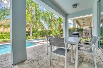 a patio with a table and chairs and a swimming pool at 650 Lasso Drive in Orlando