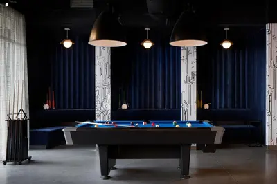 a pool table in a room with blue curtains at Aloft Orlando International Drive by Marriott in Orlando