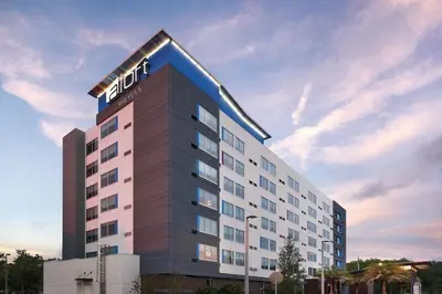 a hotel building with a sign on the top of it at Aloft Orlando International Drive by Marriott in Orlando