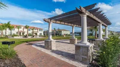 a wooden pergola with a brick walkway at Family Resort - 4BR Home Near Disney - Private Pool, BBQ! in Kissimmee