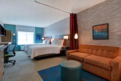 a hotel room with a bed and a couch at Home2 Suites By Hilton Orlando Flamingo Crossings, FL in Orlando