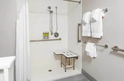 a white bathroom with a shower and a sink at Holiday Inn Express & Suites Sanford - Lake Mary by IHG in Sanford