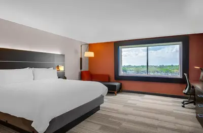 a hotel room with a bed and a desk and a window at Holiday Inn Express & Suites Sanford - Lake Mary by IHG in Sanford
