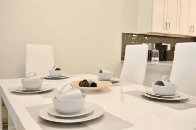 a table with plates and cups on it in a kitchen at High end apartment in luxurious Storey Lake community Next to Disney! in Kissimmee