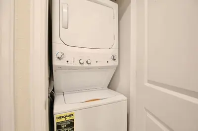 a microwave sitting on top of a washer and dryer at High end apartment in luxurious Storey Lake community Next to Disney! in Kissimmee