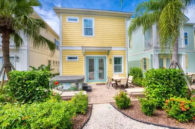 a yellow house with a patio and palm trees at Don't Worry, Beach Happy Cottage Near Disney With Private Hot Tub & Margaritaville Resort & Island H20 Waterpark Access - 3005Sp in Orlando
