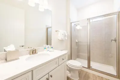 a white bathroom with a toilet and a shower at Don't Worry, Beach Happy Cottage Near Disney With Private Hot Tub & Margaritaville Resort & Island H20 Waterpark Access - 3005Sp in Orlando