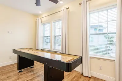 a ping pong table in a room with windows at Toes In The Water Cottage With Private Pool Near Disney With Margaritaville Resort & Island H2O Access - 8008Sh in Orlando