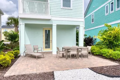 a patio with a table and chairs in front of a house at Vivid Cottage Near Disney With Margaritaville Resort & Island H2O Access - 8024Ls in Orlando