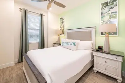 a bedroom with a white bed and a window at Lovely Green Cottage Near Disney With Margaritaville Resort & Island H20 Waterpark Access - 2982Sr in Orlando