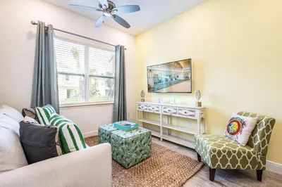 a living room with a couch and chairs and a window at Lovely Green Cottage Near Disney With Margaritaville Resort & Island H20 Waterpark Access - 2982Sr in Orlando